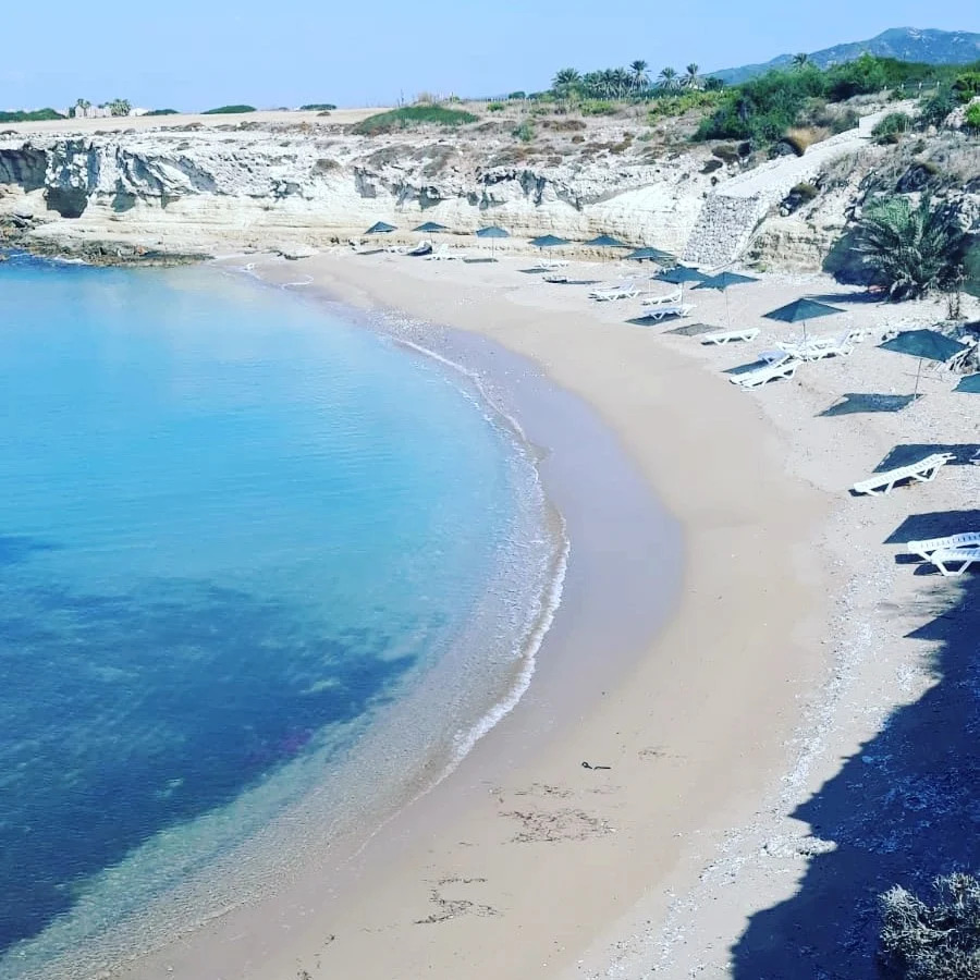 Private beach with sun loungers and umbrellas